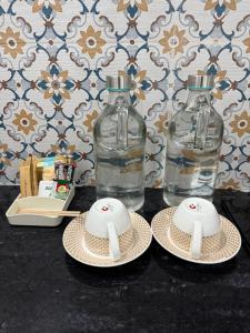 dos botellas de agua y dos sombreros en una mesa en Dhaulidhar Farms, en Greater Noida
