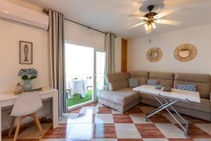 een woonkamer met een bank en een tafel bij Todimer Ohana Beach in Salobreña