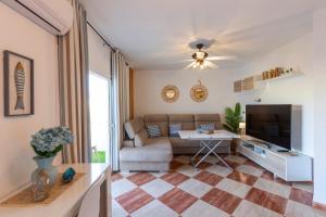 een woonkamer met een bank en een tv bij Todimer Ohana Beach in Salobreña