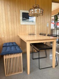 a wooden table with a chair and a table with a stool at Architect designed micro house in Skage +46 photos