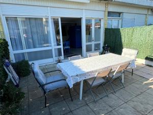 a white table and chairs on a patio at Charmant appartement en rez-de-chaussée à 150m de la plage in Saint-Georges-de-Didonne