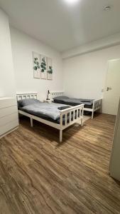 two beds in a room with wood floors at Ferienwohnung-Monteurwohnung ANTON bis zu 4 Personen in Kleve, zentrale Lage in Kleve