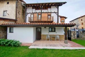 a house with a balcony with a table and chairs at Zumargain in Asteasu