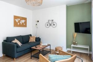 a living room with a blue couch and a table at Grand appartement Rue Caponiere - Centre de Caen à pied in Caen