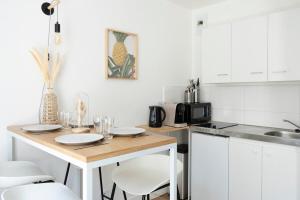 a kitchen with a wooden table and white cabinets at Grand appartement Rue Caponiere - Centre de Caen à pied in Caen +4 photos