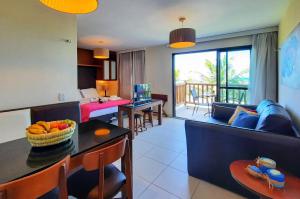 a living room with a couch and a table at VG Sun Cumbuco Nascente Vista Mar 4 Pessoas in Paracumbuca