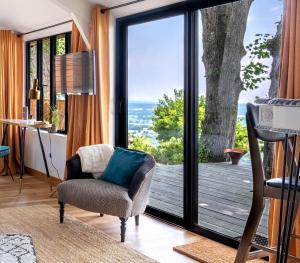 - un salon avec une chaise et une porte coulissante en verre dans l'établissement lodge-bélvédere sur les hauteurs de vichy, à Vichy