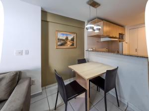a kitchen with a table and chairs and a couch at Beach Class Queridinho Apto 2Qtos 50m Praia in Fortaleza