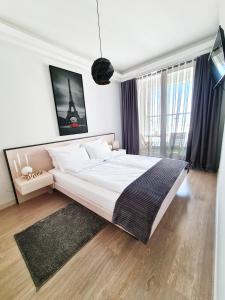 una camera da letto con un letto grande e una grande finestra di Royal Suite on the 24th Sky a Skopje