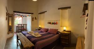 a bedroom with a bed with towels on it at Hosteria La Pushka in Purmamarca