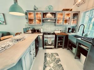 a kitchen with blue cabinets and a stove top oven at The Kingfisher in Plettenberg Bay