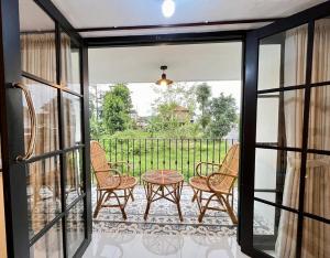 a screened in porch with a table and chairs at Villa Al-Fatih Karangpandan in Pablengan +2 photos