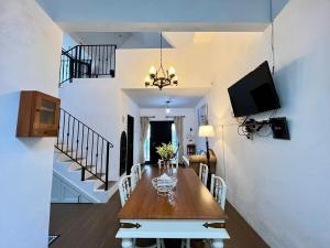 a dining room with a table and a tv on a wall at Villa Al-Fatih Karangpandan in Pablengan