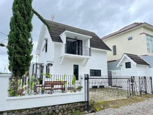 a white house with a fence in front of it at Villa Al-Fatih Karangpandan in Pablengan