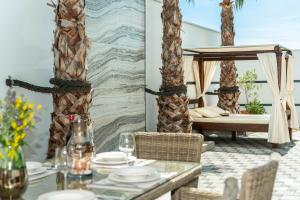 a dining room with a table and a bed and palm trees at MY DALMATIA - Luxury villa Michelle with private infinity pool, sea view jacuzzi, sauna and home gym in Maslenica