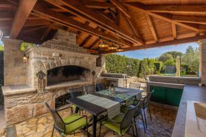 eine Außenterrasse mit einem Steinkamin sowie einem Tisch und Stühlen in der Unterkunft Villa Palma in Zaton