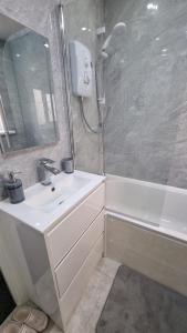 a bathroom with a white sink and a shower at Cosy Retreat Your Home Away in Portsmouth