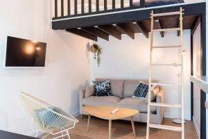 ein Wohnzimmer mit einem Sofa und einem Hochbett in der Unterkunft Appartement proche Place Saint-Sauveur in Caen