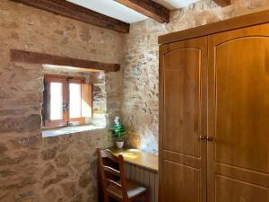 a room with a wooden cabinet and a table and a window at CASA RURAL CARRER PLA Culla in Culla +6 photos