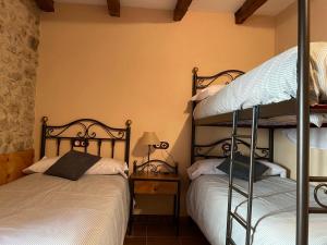 a bedroom with two bunk beds and a lamp at CASA RURAL CARRER PLA Culla in Culla
