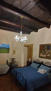 a bedroom with a blue bed and a chandelier at palazzo RICCARDI in Solopaca
