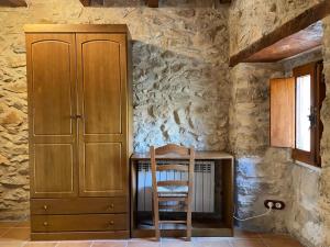 a room with a table and a cabinet and a chair at CASA RURAL CARRER PLA Culla in Culla