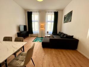 莱比锡Zu Fuß ins Zentrum, nahe Arena的客厅里有一张黑色沙发和一张桌子 更多9张照片