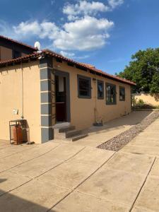 une petite maison blanche avec une allée en face de celle-ci dans l'établissement Silent corner guest house, à Roodepoort