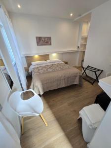 una camera con letto e sedia bianca di Athena ad Alghero