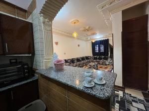een keuken met aanrechtblad en een woonkamer bij Habiba Apartment in Luxor