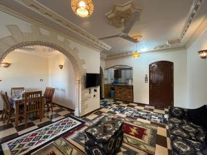 een woonkamer met een tafel en een keuken bij Habiba Apartment in Luxor