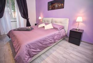 ein violettes Schlafzimmer mit einem großen Bett mit violetter Bettwäsche in der Unterkunft Viale del Colosseo in Rom