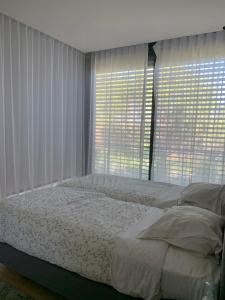 a bedroom with a bed and two large windows at Summer Villa in Troia +4 photos