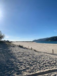 a sandy beach with a fence on the side at Summer Villa in Troia