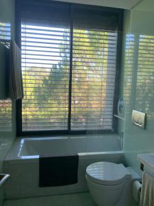 a bathroom with a tub and a toilet and a window at Summer Villa in Troia