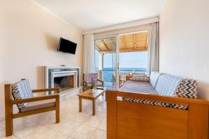 a living room with a couch and a fireplace at Lido Sofia Apartments in Agios Gordios