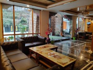 a living room with leather furniture and a table at Nature Nest's Resort in Rongli +85 photos