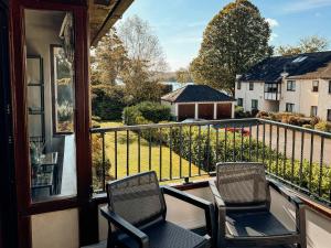 two chairs on a balcony with a view of a yard at Bellman's Hideaway in Bowness-on-Windermere