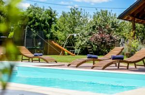 a group of chairs sitting next to a swimming pool at Kuća lješnjaka in Ludbreg