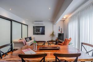 ein Wohnzimmer mit einem Holztisch und Stühlen in der Unterkunft Casa Mallet by Wynwood House in Panama-Stadt + 66 Fotos