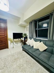 セブシティにある31T1 Chic Corner, Horizons 101, Cebu Cityのリビングルーム(緑のソファ、テレビ付)