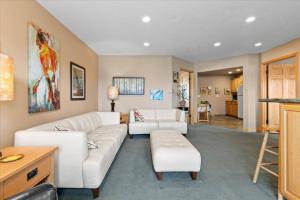 a living room with two white couches and a table at Cozy 2.4 in Hayden