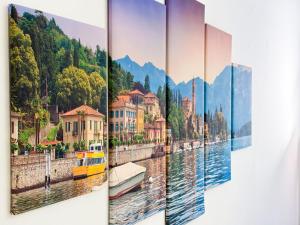 a group of four paintings hanging on a wall at Voltiva House - in the Heart of Como Old Town in Como