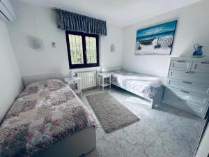 a bedroom with two beds and a dresser and a window at "Traumhaftes Ferienhaus mit Pool und Meerblick - Cumbre del Sol erleben!" in Benitachell +36 photos