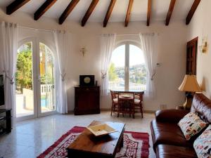 a living room with a couch and a table at "Traumhaftes Ferienhaus mit Pool und Meerblick - Cumbre del Sol erleben!" in Benitachell