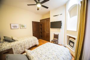 a bedroom with two beds and a ceiling fan at Villa Lavanda in San Miguel de Allende