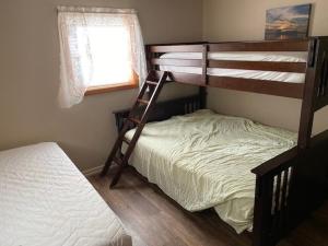 a bedroom with two bunk beds and a bed at Apple Tree Cottage -1000 Islands in Clayton