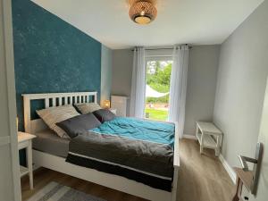 a bedroom with a bed with a blue wall at Grüne Oase - Nahe Zentrum in Bad Salzuflen