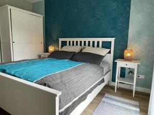 a bedroom with a bed with a blue wall at Grüne Oase - Nahe Zentrum in Bad Salzuflen