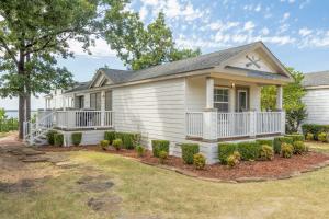 a white house with a porch and bushes at CrossTimbers Marina and Cottages in Sperry +64 photos